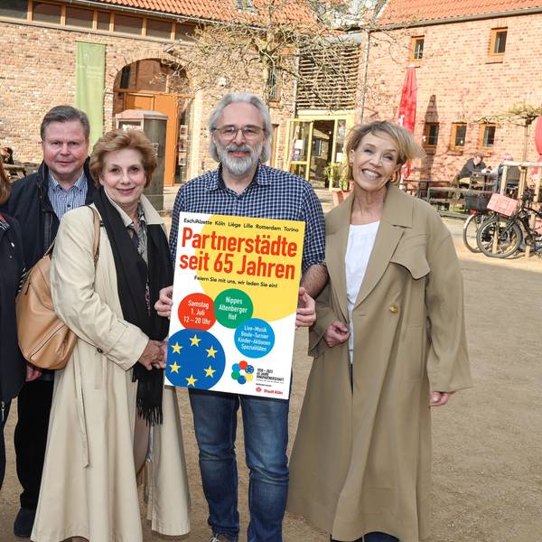 Vertreterinnen und Vertreter der Fördervereine mit einem Plakat vor dem Altenberger Hof in Nippes