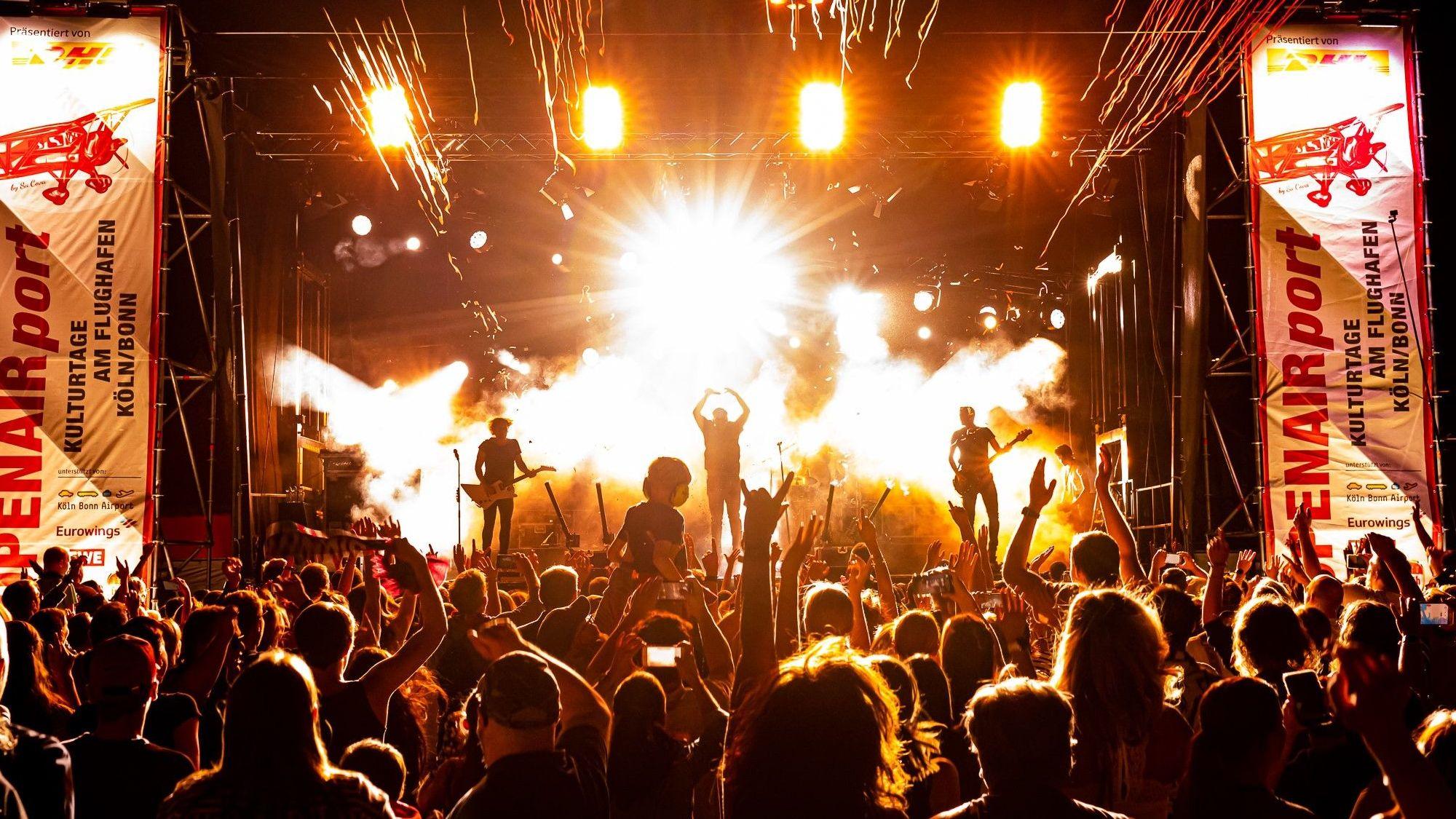 Bühne mit Menge davor im Dunkeln mit Licht-Show