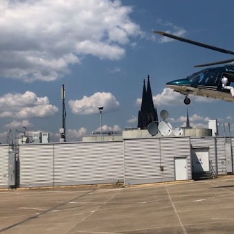 Ein Influencer sitzt in einem Helikopter über dem Parkdeck von Galeria Kaufhof in der Kölner Innenstadt.