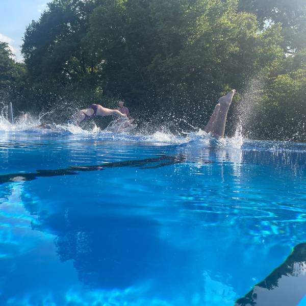 Schwimmer springen in ein Wasserbecken.