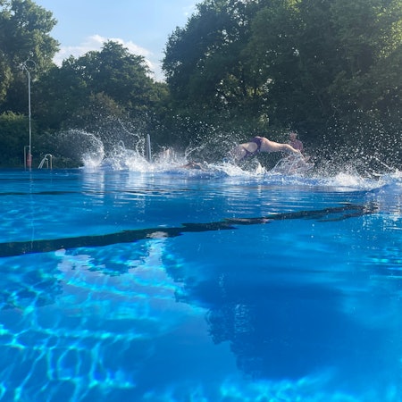 Schwimmer springen in ein Wasserbecken.