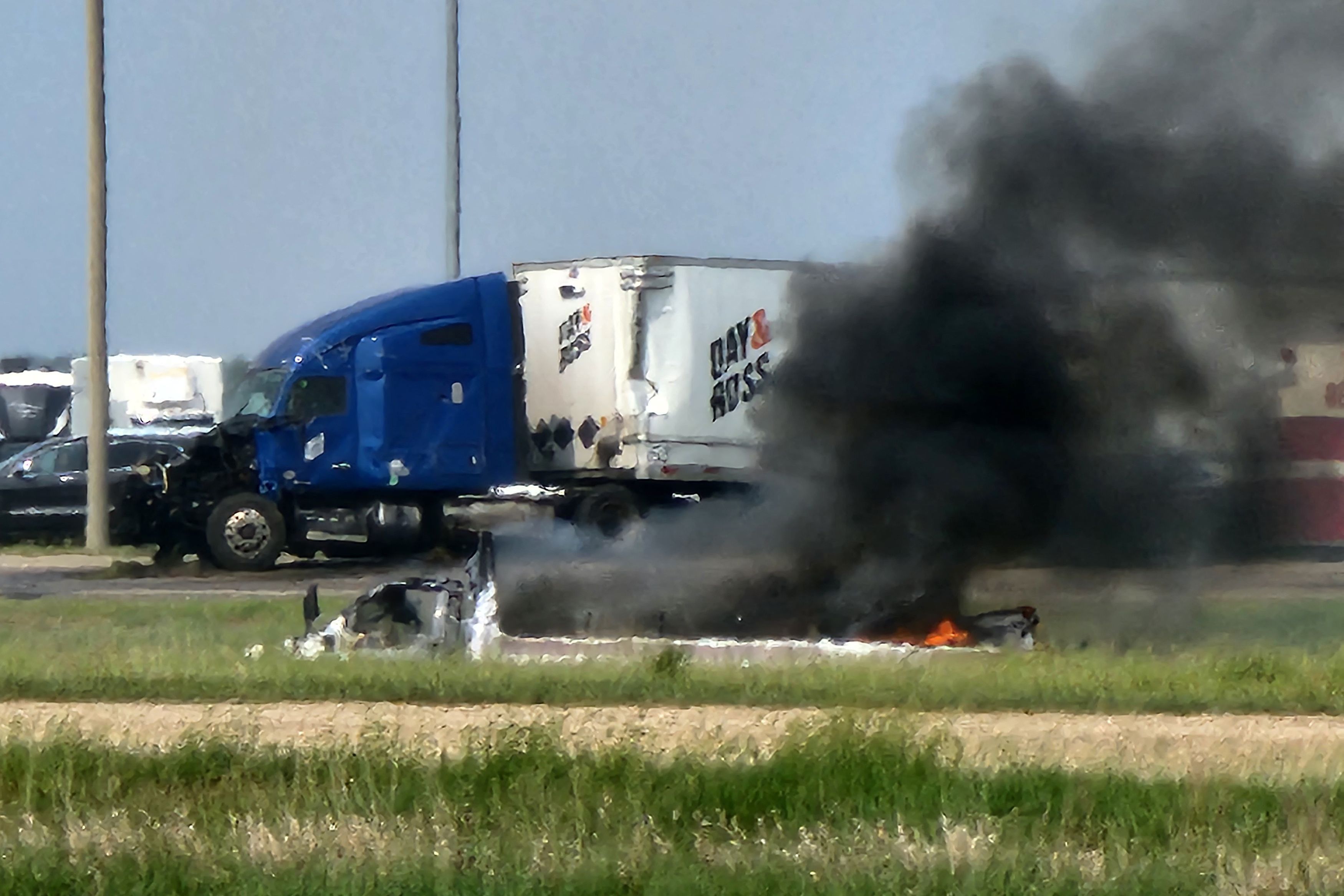 Nach einem Verkehrsunfall mit 15 Toten steigt Rauch aus einem Auto auf.
