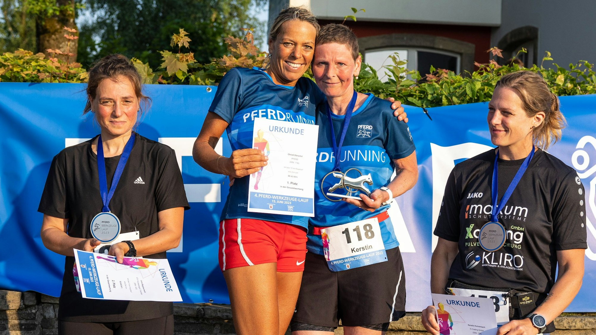Zu sehen sind vier Frauen auf einem Siegertreppchen.