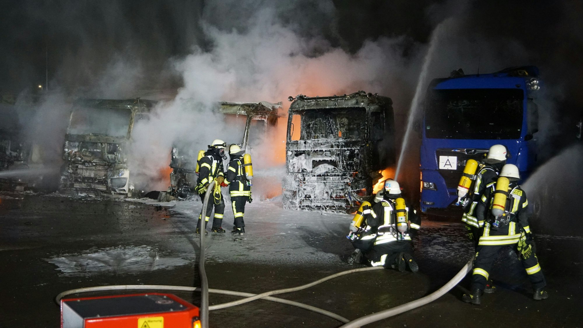 Mehrere Weilerswister Feuerwehrleute löschen brennende Lkw.