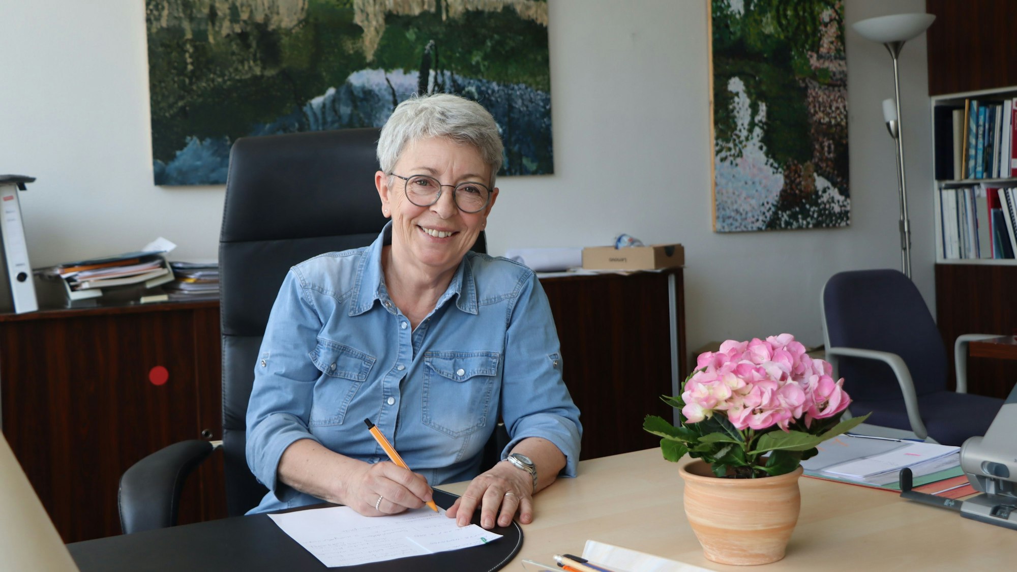 Auf dem Foto ist Karin Freiburg an ihrem Schreibtisch zu sehen.