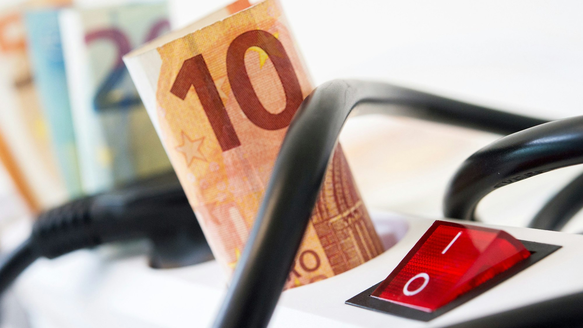 Geldscheine stecken in einer Steckerleiste.