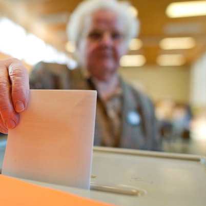 Eine Wählerin wirft ihren Stimmzettel in eine Wahlurne.