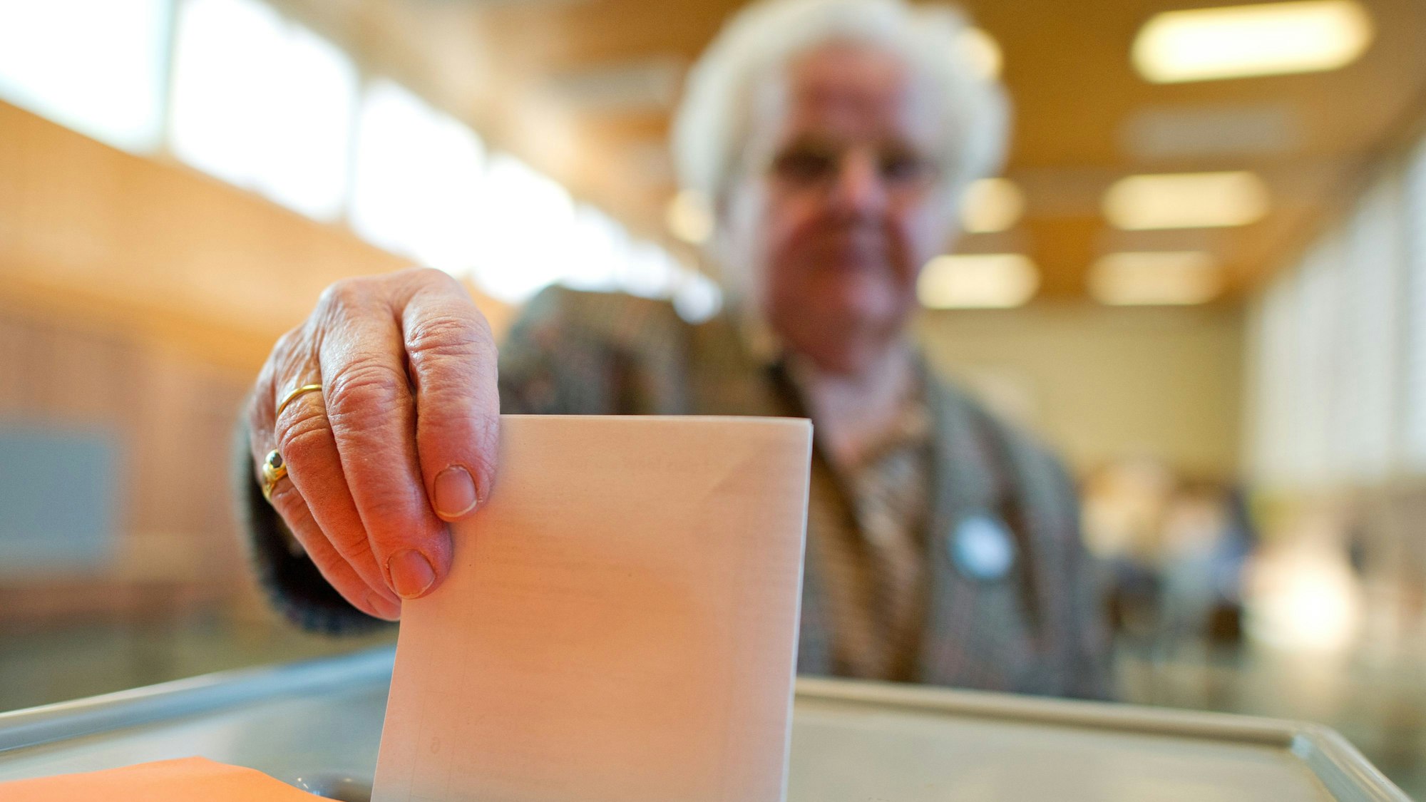 Eine Wählerin wirft ihren Stimmzettel in die Wahlurne.