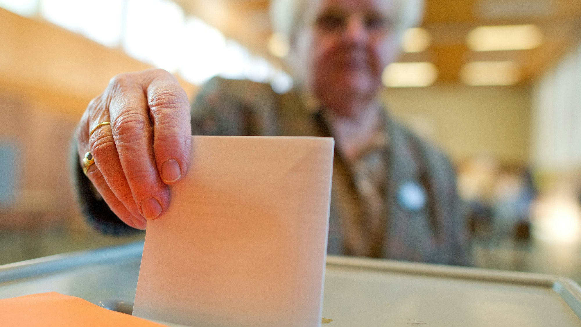 Eine Wählerin wirft ihren Stimmzettel in eine Wahlurne.