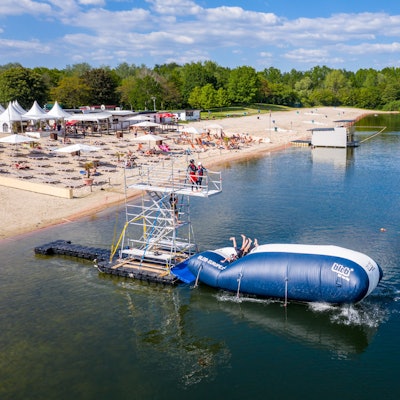 Turmspringer der Splashdiving-Gruppe „Cologne Bombs“ springen am Otto-Maigler-See von einem sogenannten „Blob“ ins Wasser. Hierbei liegen die Personen auf einem Luftkissen und werden in die Luft geschleudert, wenn am hinteren Ende ein oder mehrere Personen auf das Kissen springen.
