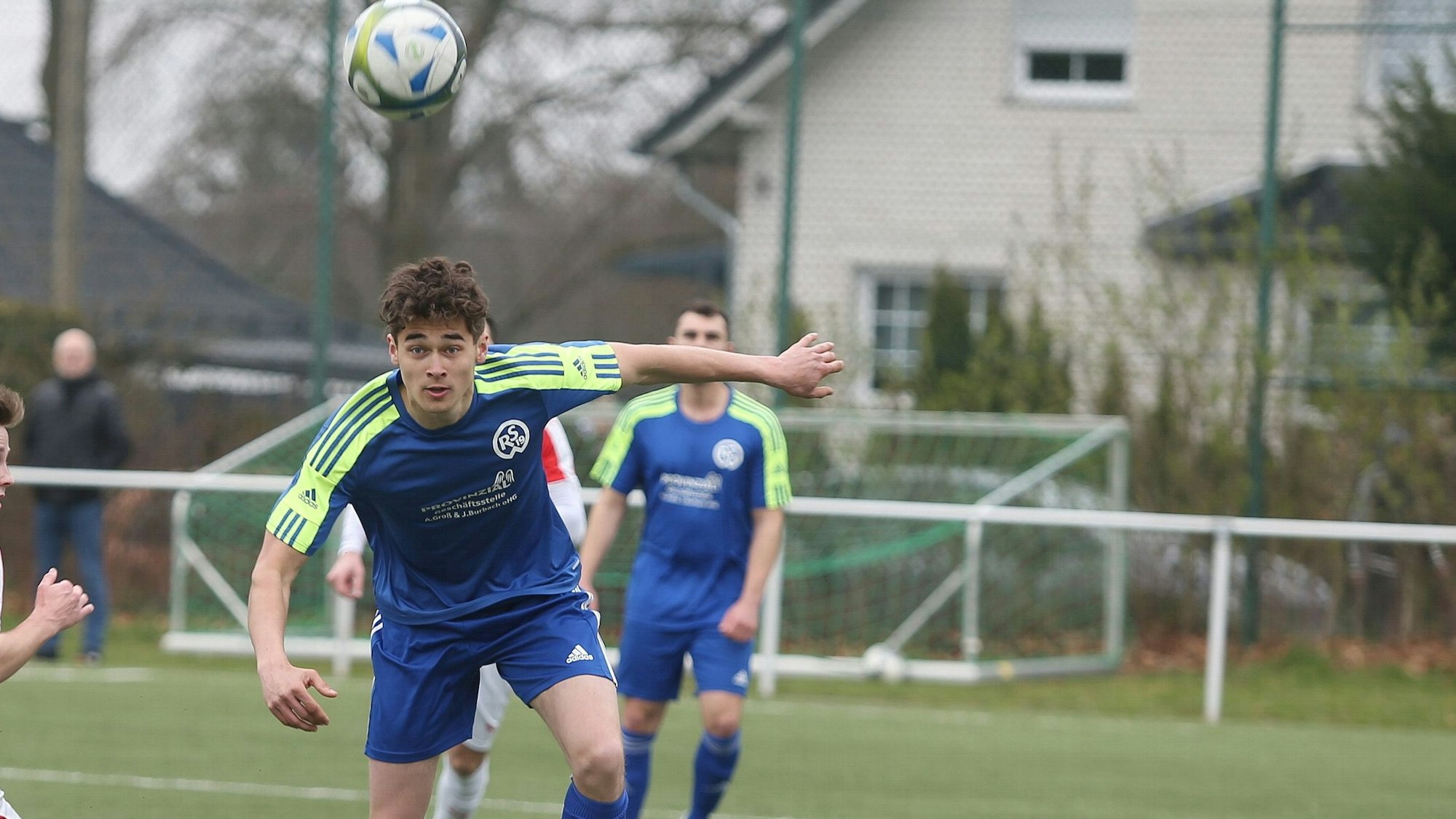 Im Bild ist ein Fußballspieler zu sehen, der den Ball mit dem Kopf annimmt.