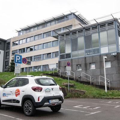 Das Rathaus Lindlar ist im Hintergrund zu sehen, vorne steht ein weißes Auto.