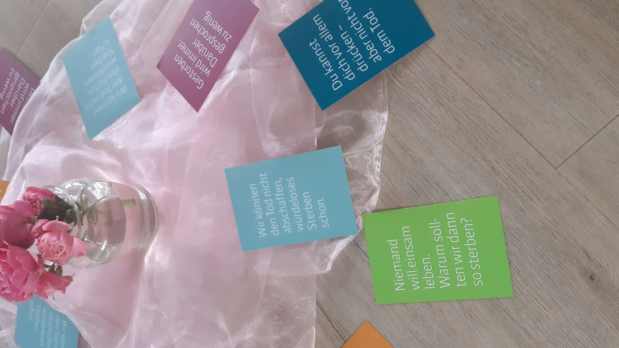 Karten mit Sprüchen zum Thema Tod sind auf dem Boden verteilt.