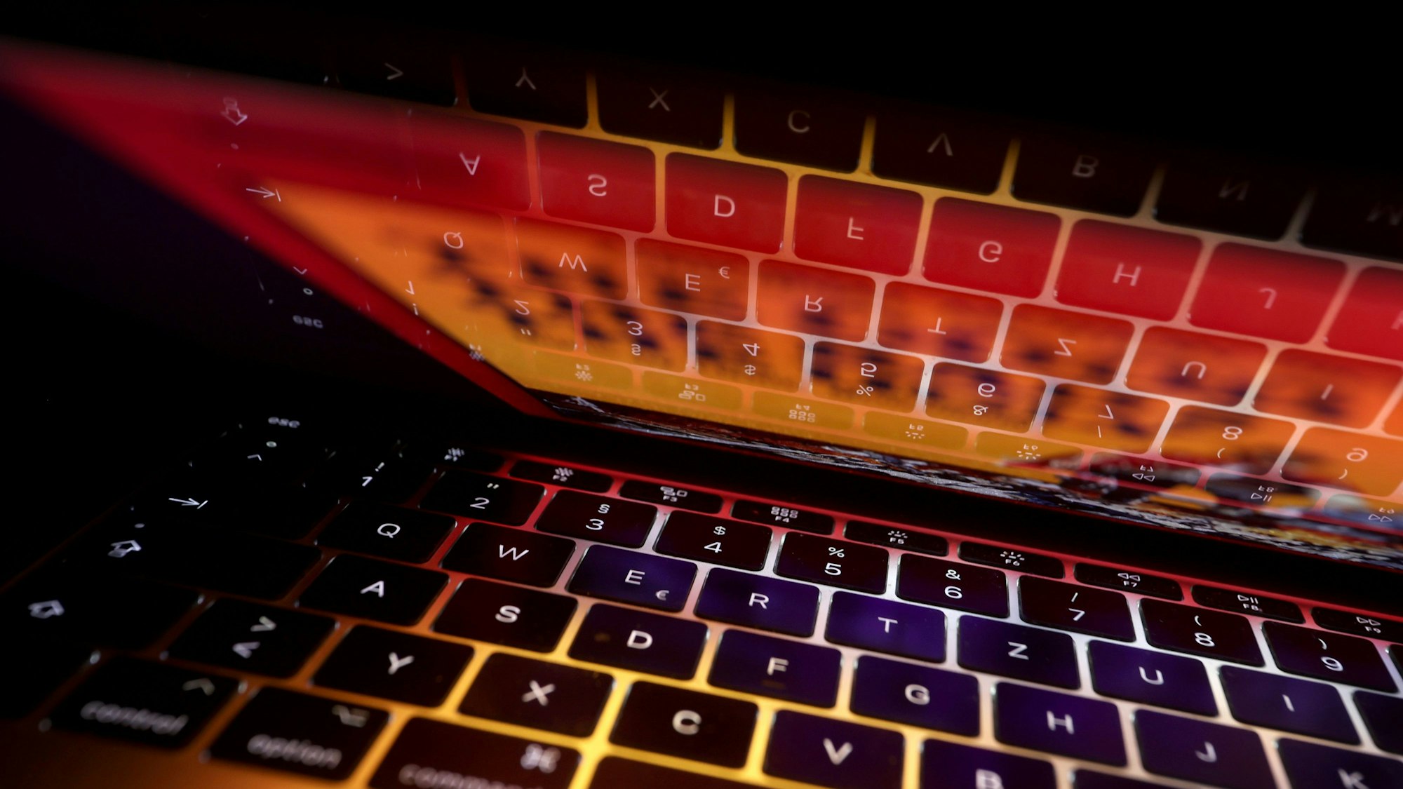Die Tastatur eines Laptops spiegelt sich in dessen Bildschirm.