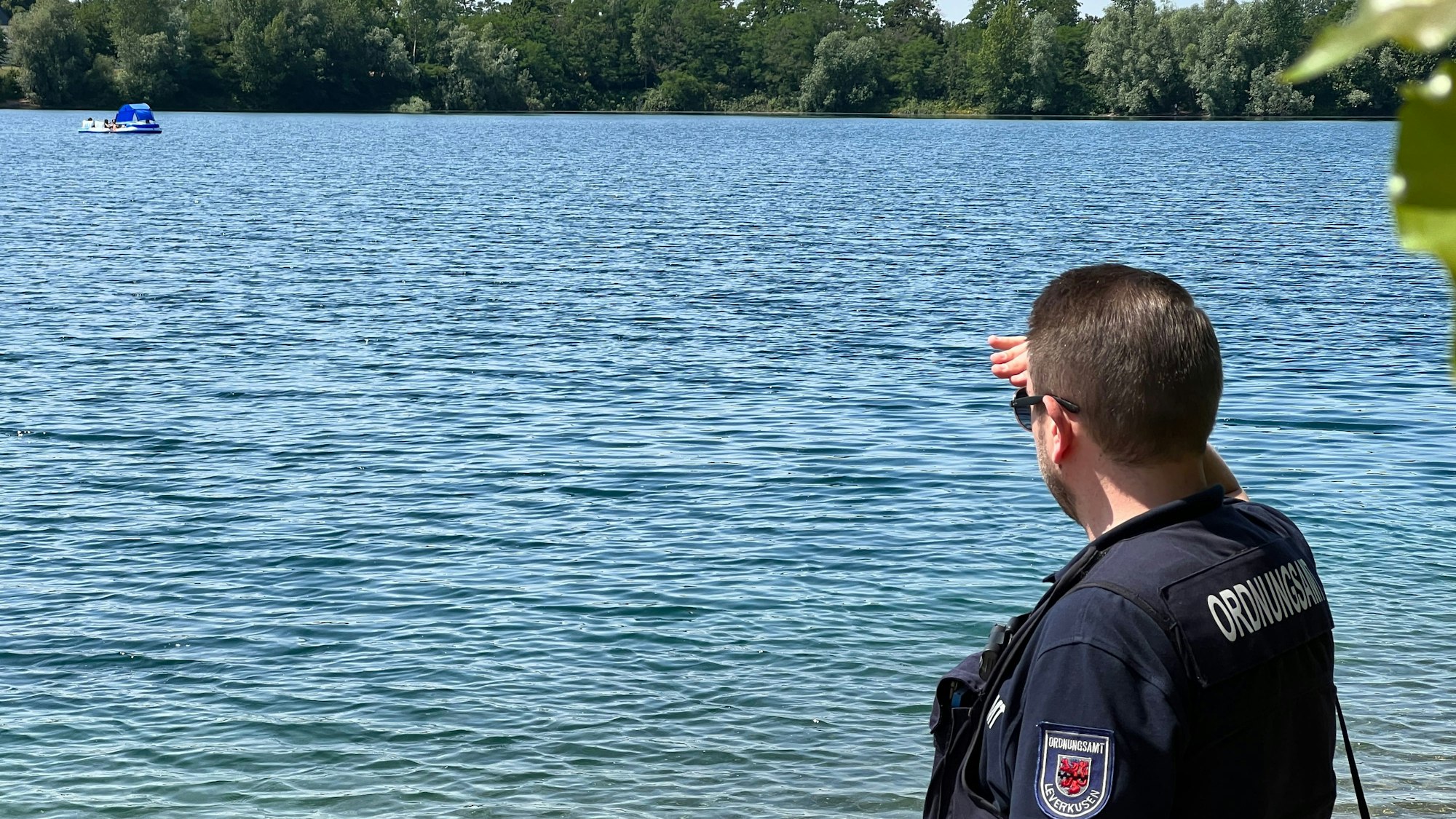 Marcus Richter, Leiter des Kommunalen Ordnungsdienstes, beobachtet ein Floß auf dem Stöckenbergsee.