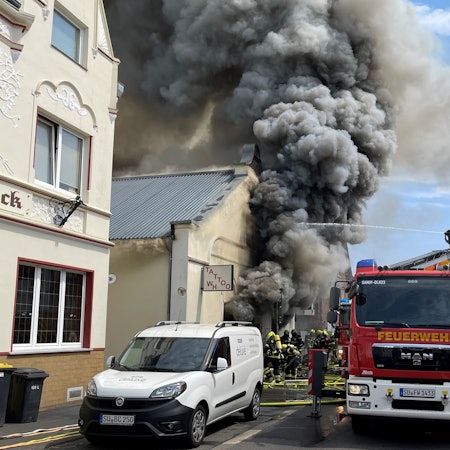 Aus einem Gebäude quillt dichter, dunkler Rauch.