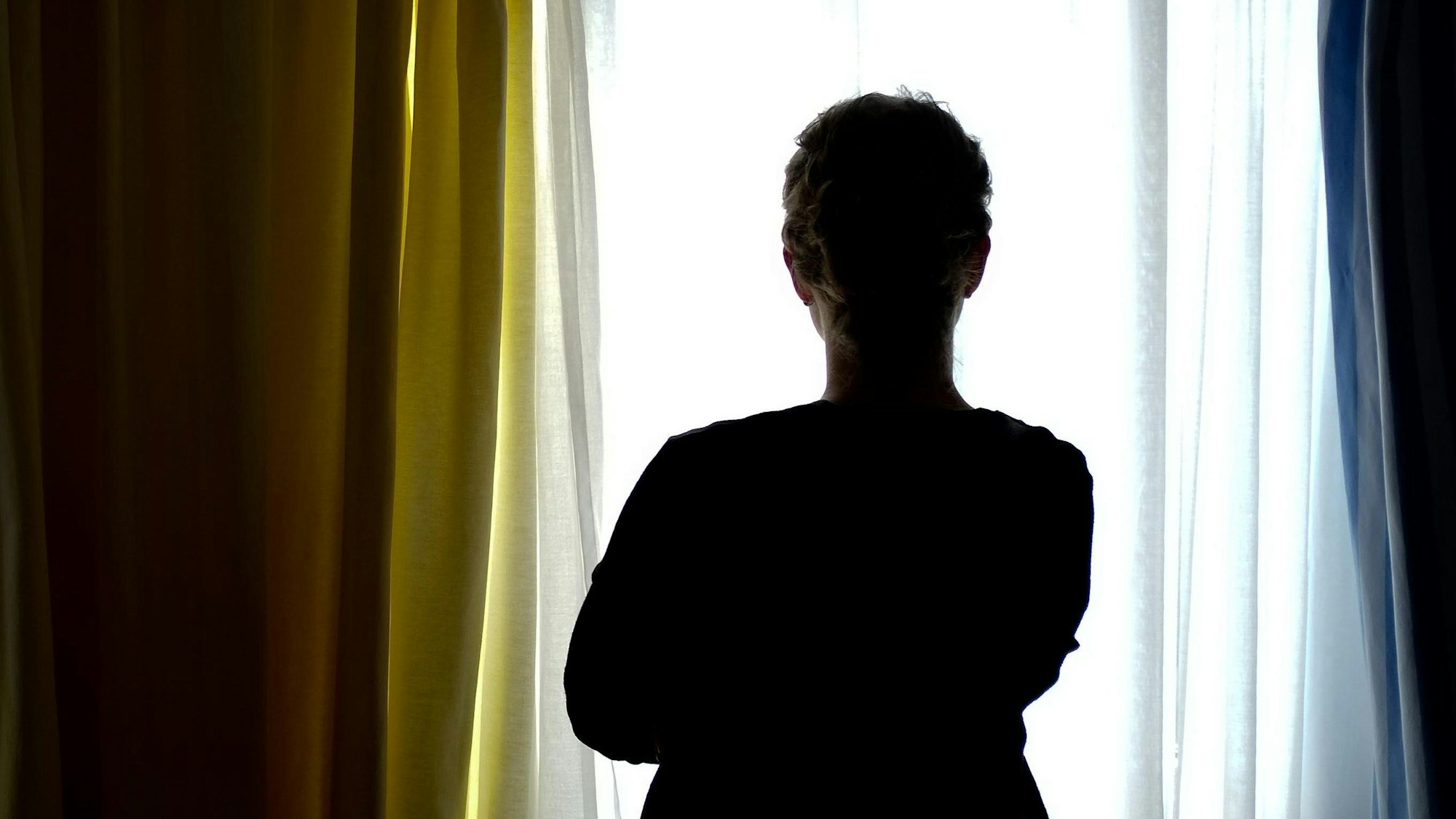 ARCHIV - 28.08.2013, Niedersachsen, Nienburg: ILLUSTRATION - Eine junge Frau steht in einem Zimmer eines Frauenhauses. Bundesinnenministerin Faeser appelliert an Opfer häuslicher Gewalt, die Taten häufiger anzuzeigen. (zu dpa «Faeser: Müssen Opfer häuslicher Gewalt stärken - Arbeit an Lagebild») Foto: Peter Steffen/dpa +++ dpa-Bildfunk +++