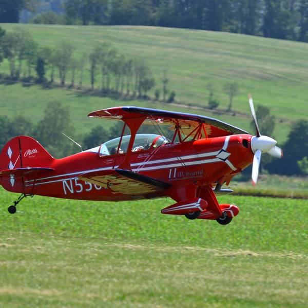 Ein Doppeldecker fliegt über die Piste auf dem Dümpel.