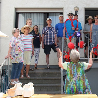 Mehrere Männer und Frauen, Mitglieder eines Chores, singen bei einem Fest in Schweinheim.