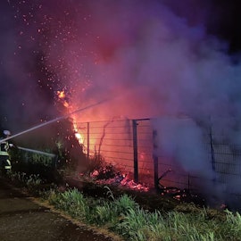 Drei Feuerwehrleute löschen ein Feuer in Kerpen.