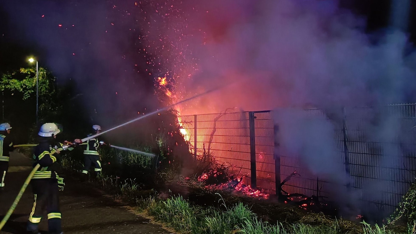 Drei Feuerwehrleute löschen ein Feuer in Kerpen.