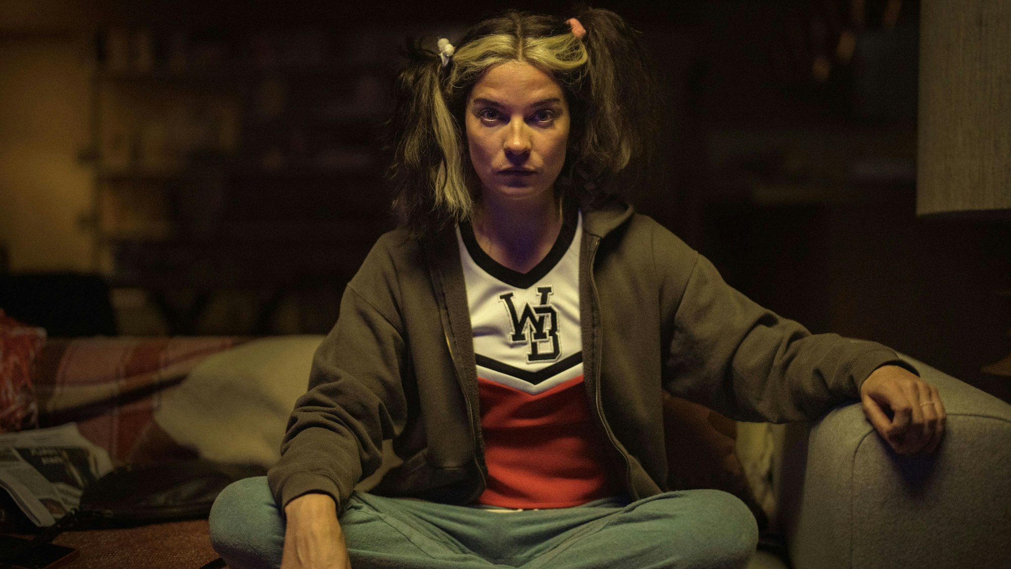 Eine Frau sitzt frustriert auf einer Couch.