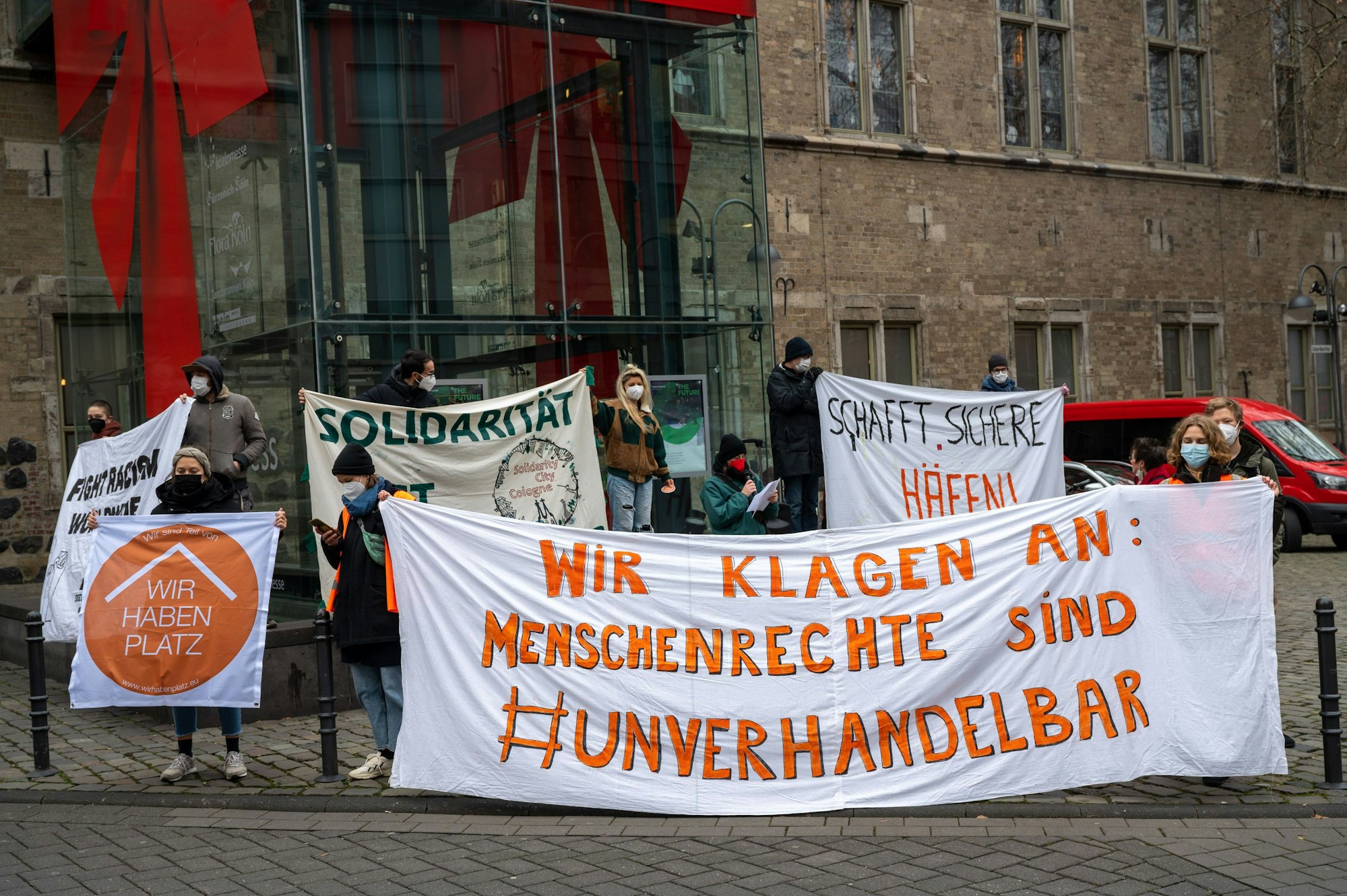 Symbolbild, Eine Gruppe Menschen hält Banner hoch und fordert Solidarität und Menschenrechte.