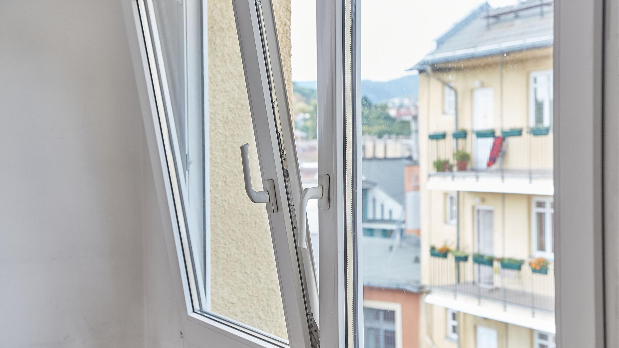 Ein gekipptes und ein geschlossenes Fenster in einem Raum.