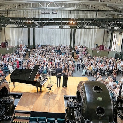 Das Bild zeigt eine Totale der Veranstaltungshalle mit Künstlern und Publikum in Heimbach.