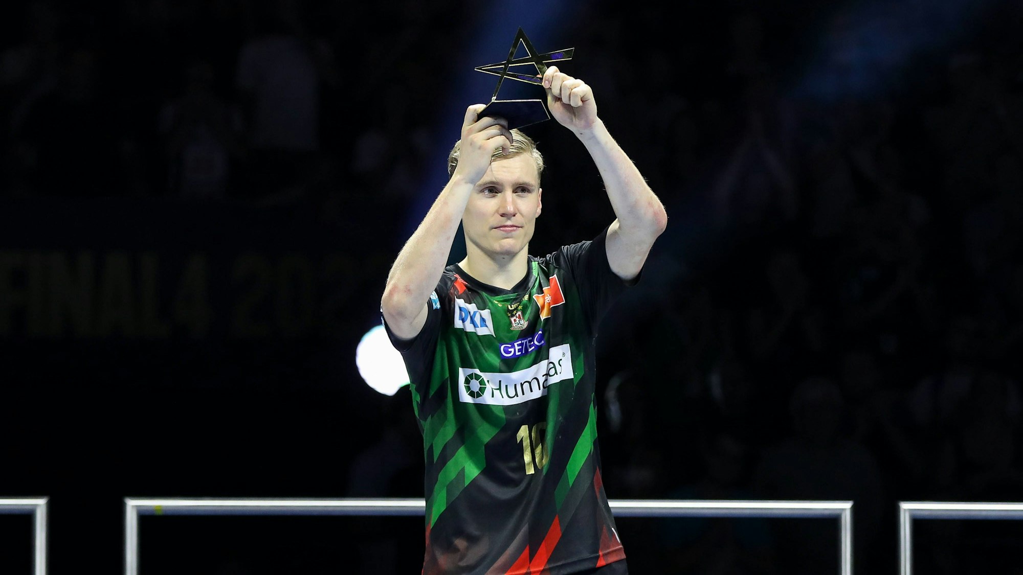 Der Isländer Gisli Kristjansson, Top-Spieler des SC Magdeburg, präsentiert in Köln eine Trophäe.