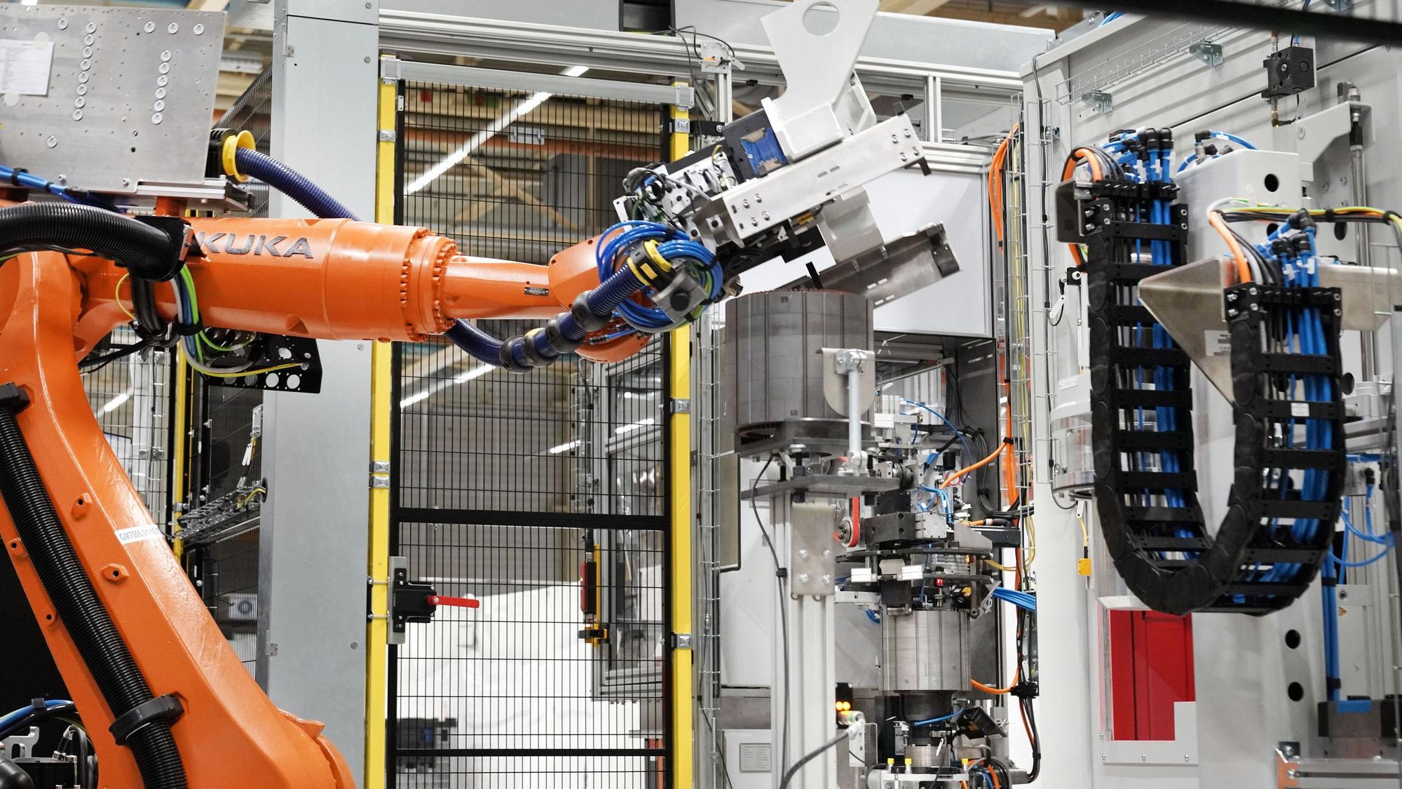 Köln, 12.10.2021 – Marelli Elektromotorenwerk in Köln. Roboter vor dem Lamellenpaket für Statoren. --- Foto Copyright: Marelli/Friedrich Stark --- Verwendung honorarfrei