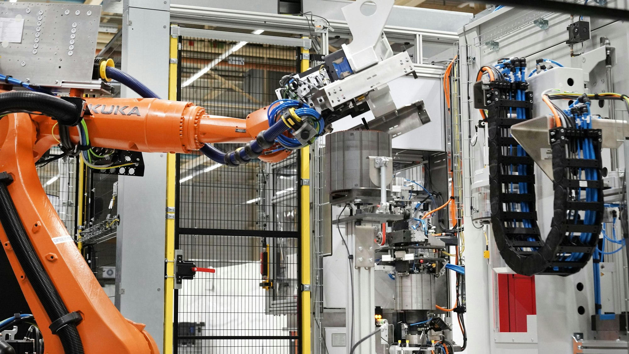 Köln, 12.10.2021 – Marelli Elektromotorenwerk in Köln. Roboter vor dem Lamellenpaket für Statoren. --- Foto Copyright: Marelli/Friedrich Stark --- Verwendung honorarfrei