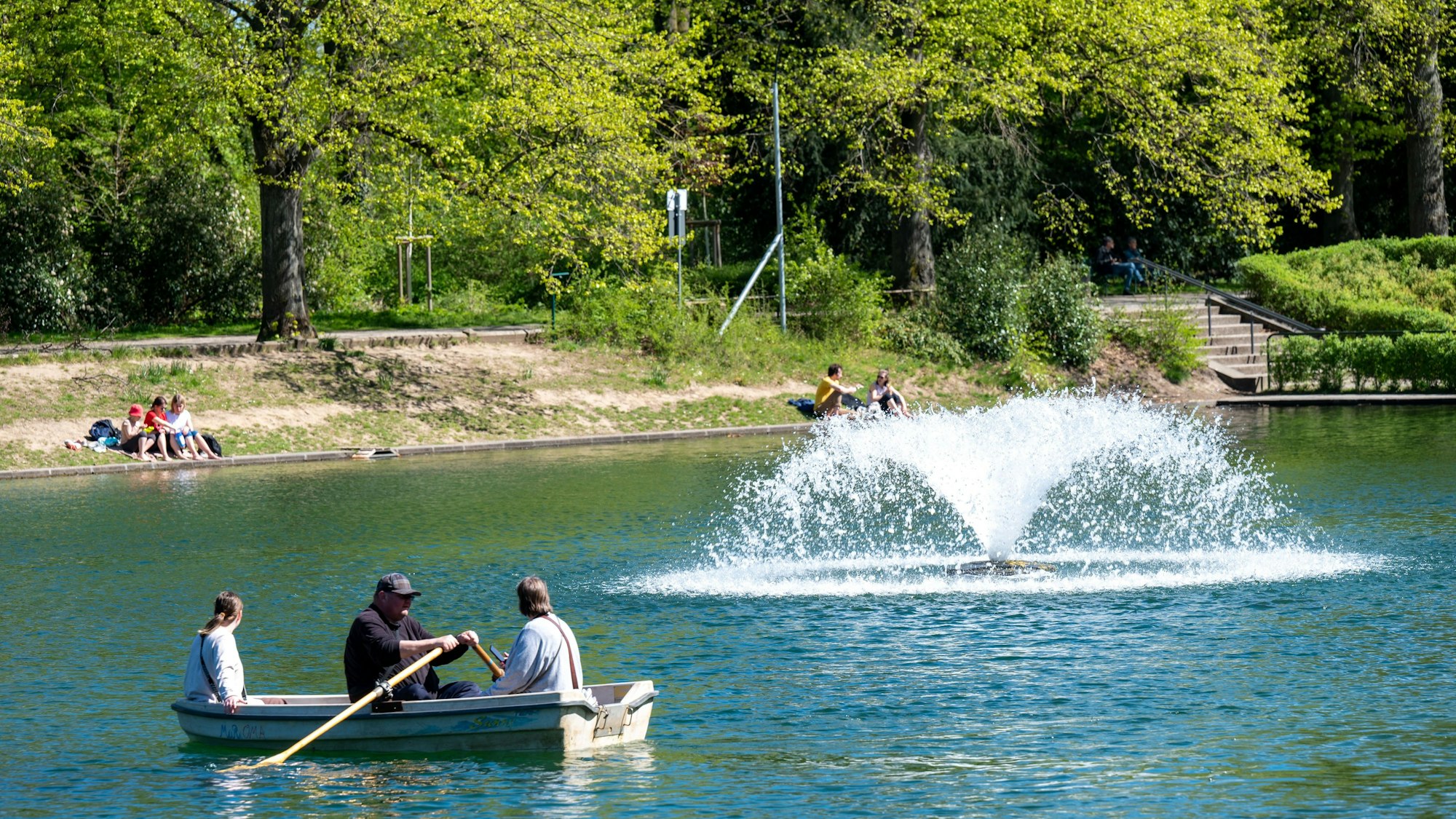 Blick auf den See im Blücherpark, auf dem Menschen Ruderbooten fahren.