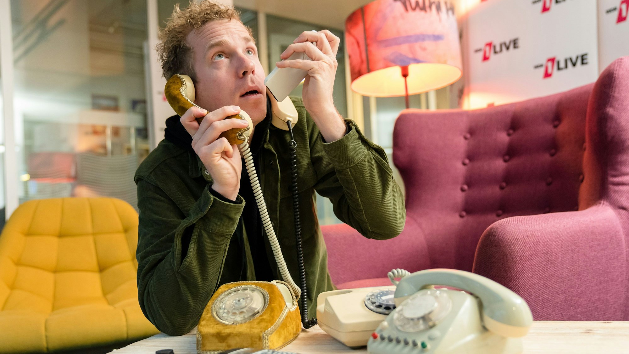 Daniel „Danger“ Schlipf posiert mit mehreren Telefonen.