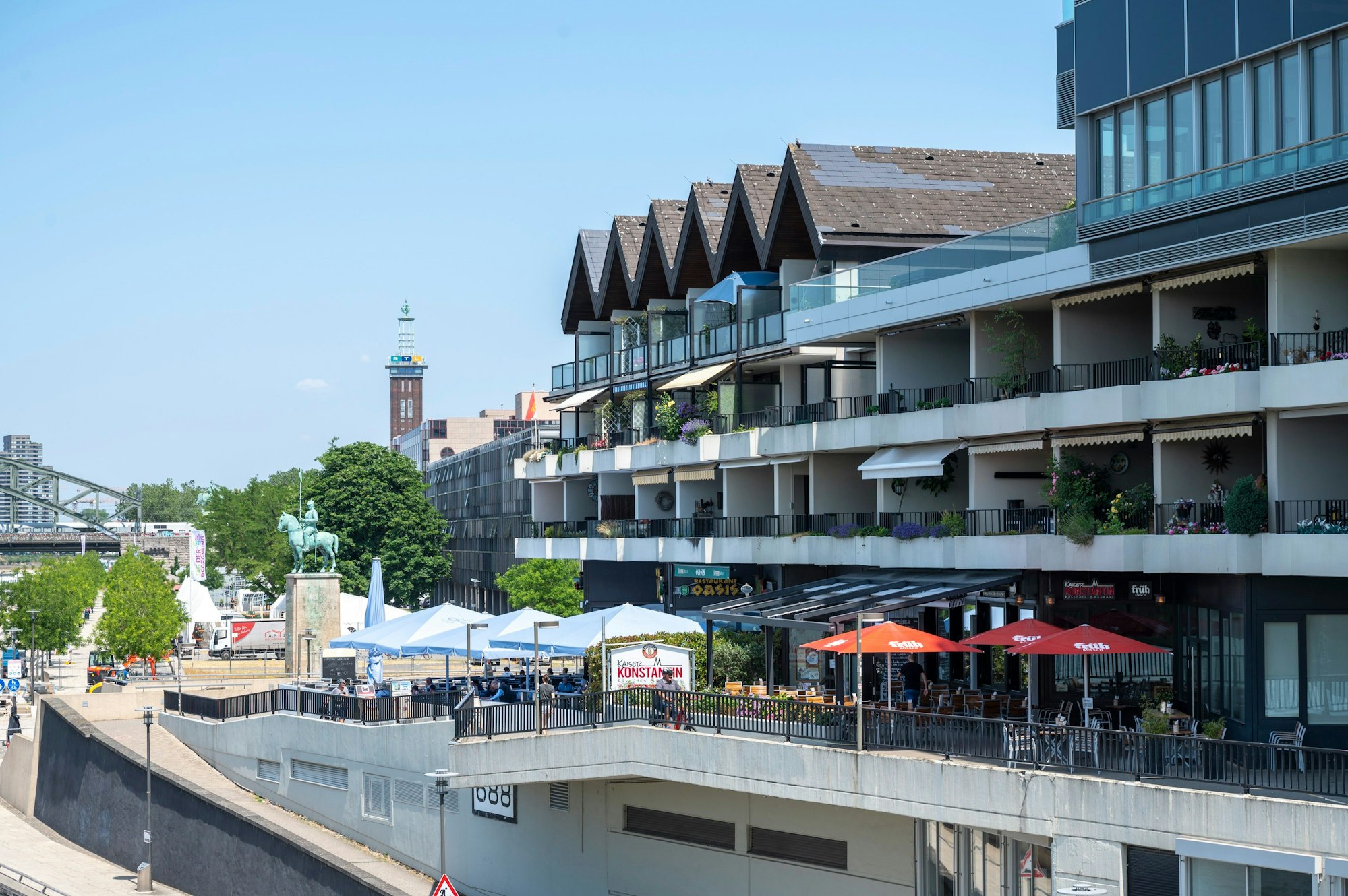 Das Haus mit den Spitzgiebeln am Deutzer Ufer, im Hintergrund die Hohenzollernbrücke und der Messeturm