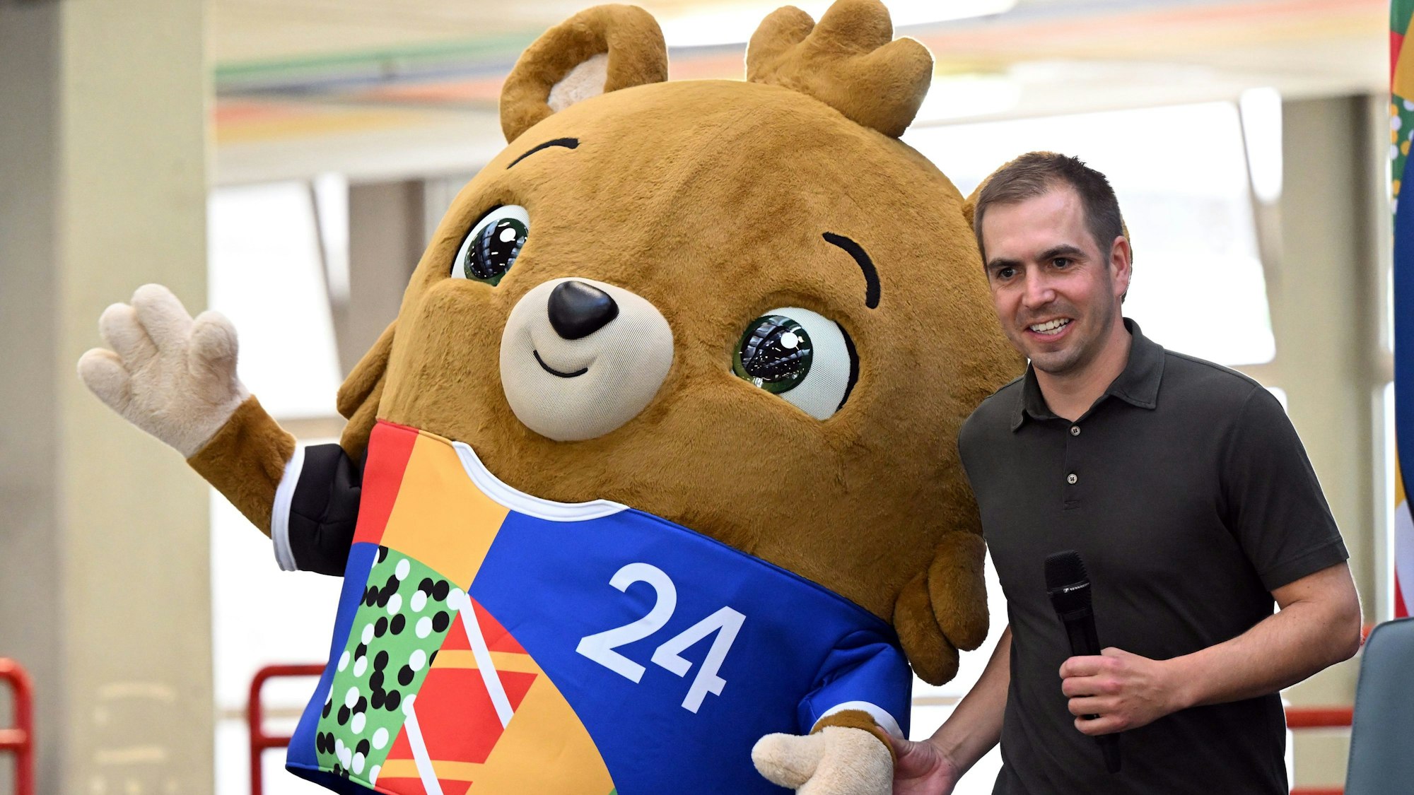 Das noch namenlose Maskottchen steht mit Turnierdirektor Philipp Lahm auf der Bühne.