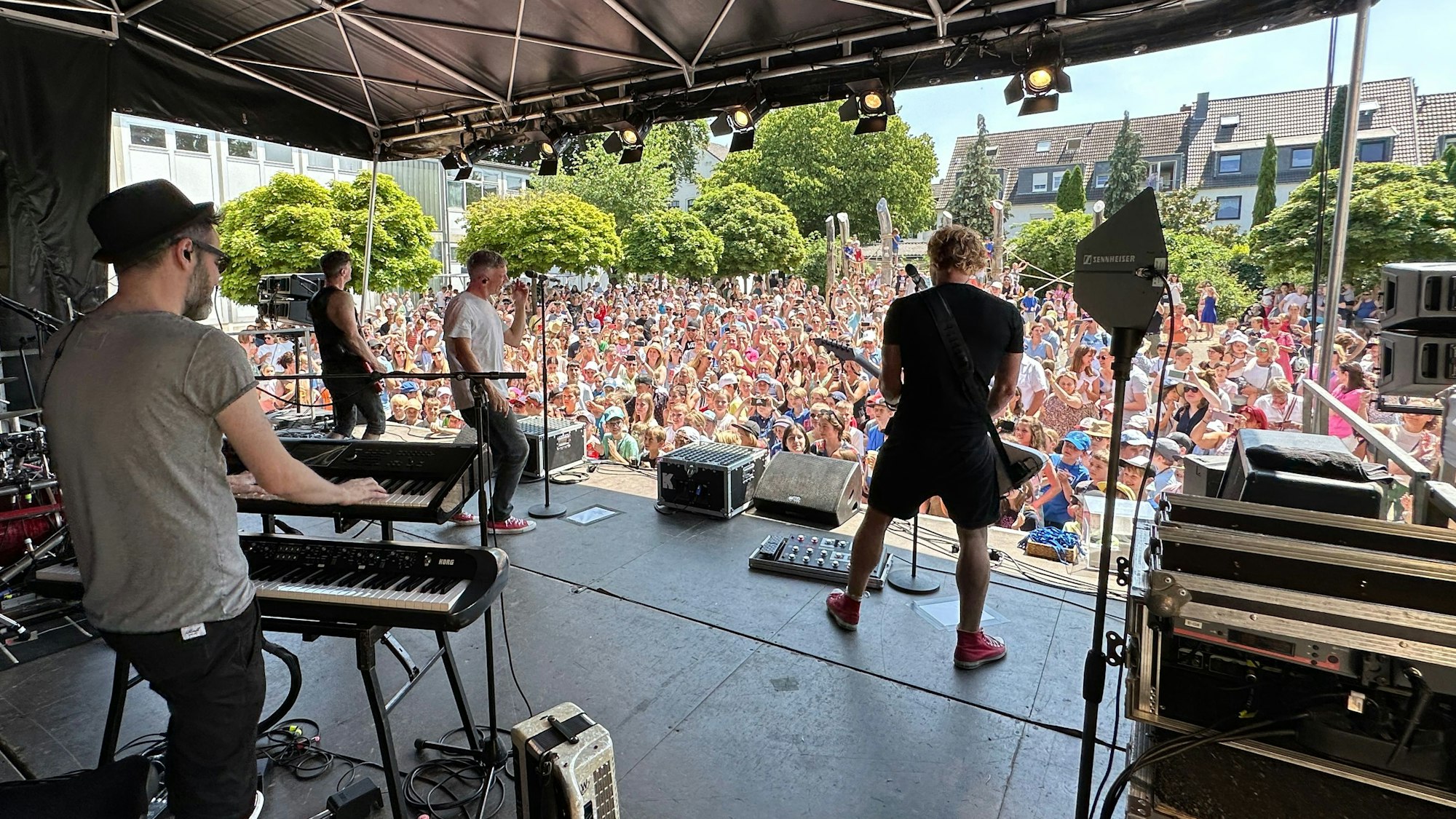 Die Band Kasalla spielt vor den Grundschülern auf der Bühne.