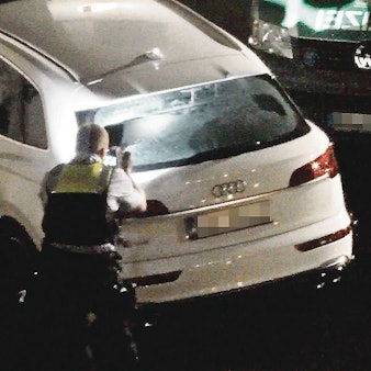 Nach den Schüssen in Troisdorf: Ein Polizist sammelt Spuren am Fahrzeug.