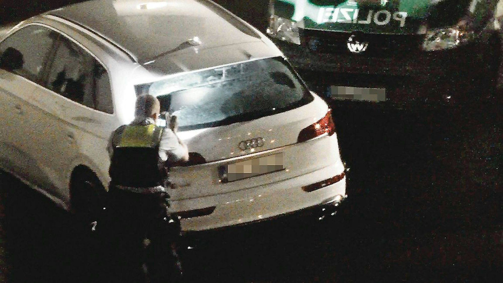 Nach den Schüssen in Troisdorf: Ein Polizist sammelt Spuren am Fahrzeug.