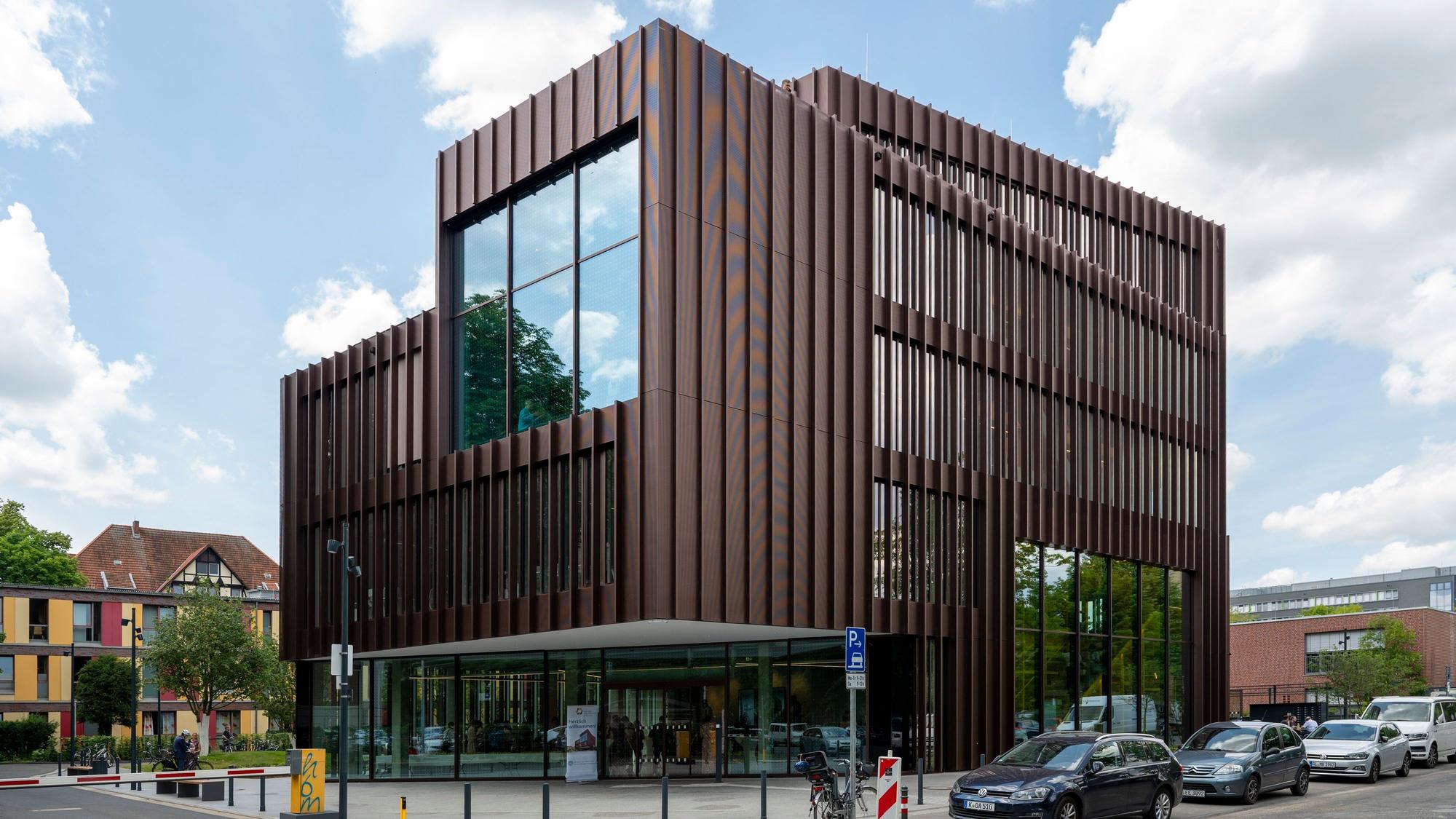 Außenansicht des Kölner Innodoms, ein fünfstöckiges, modernes, braunes Gebäude mit vielen Glasfronten