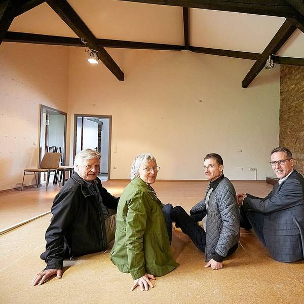 Joachim Starke, Roswitha Platzek, Thomas Kamm, Norbert Crump sitzen auf dem Boden im Obergeschoss der Begegnungsstätte in Nettersheim.