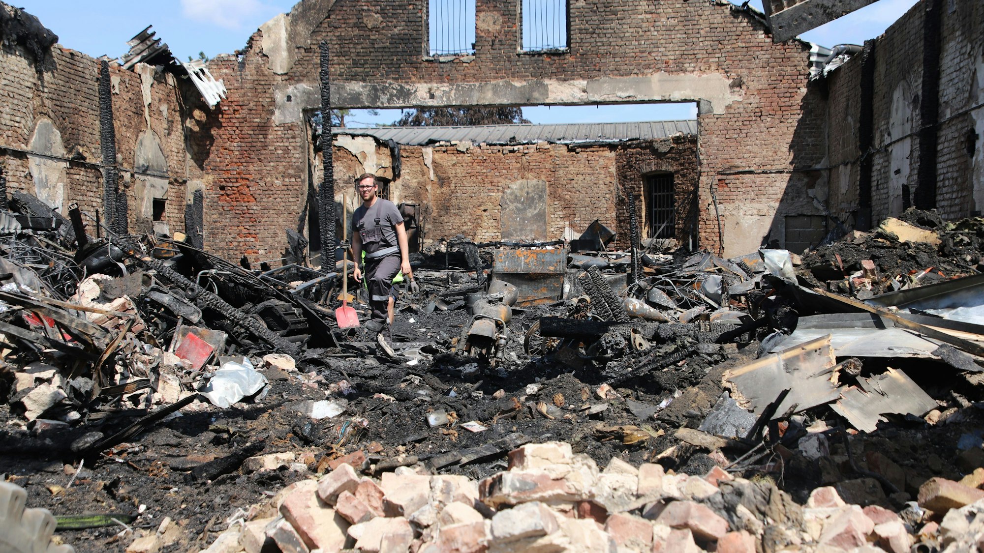 Der Brandsachverständige begeht das Innere des ausgebrannten Hauses, nachdem Giebel und Front abgetragen wurden.