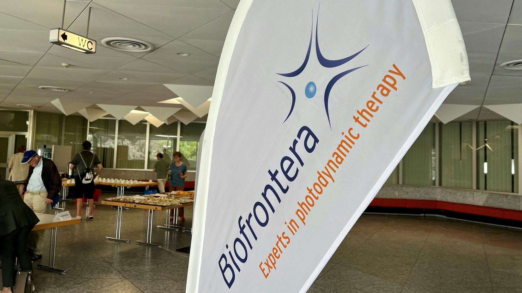 Ein Biofrontera-Wimpel steht vor dem Agamsaal im Forum.