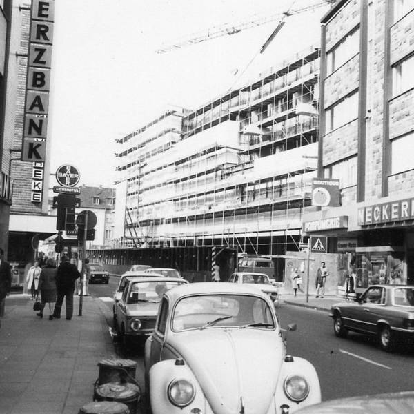 Blick auf die Kaiserstraße. Einige Autos parken am Straßenrand. Der Kaufhof ist noch eingerüstet. (Archivbild)