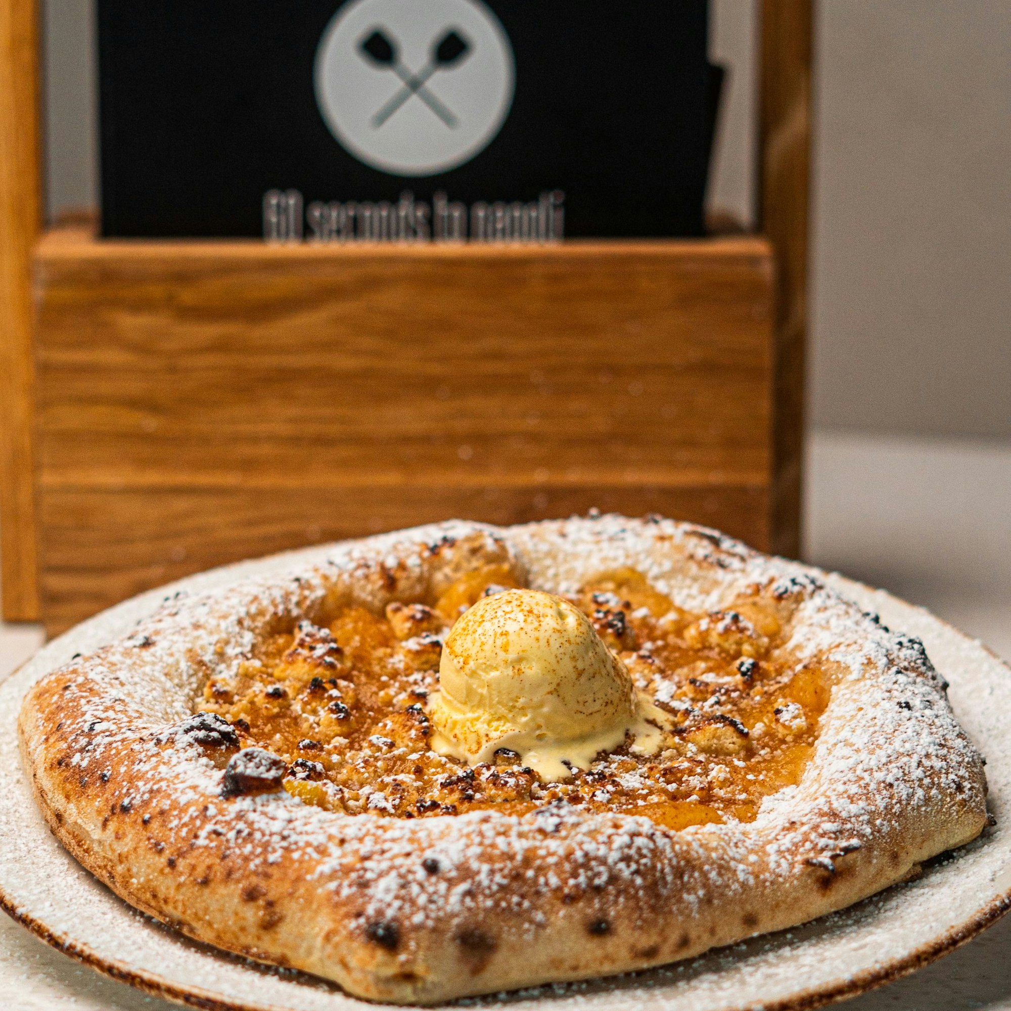 Eine Pizza mit einer Kugel Eis belegt steht auf einem Tisch.