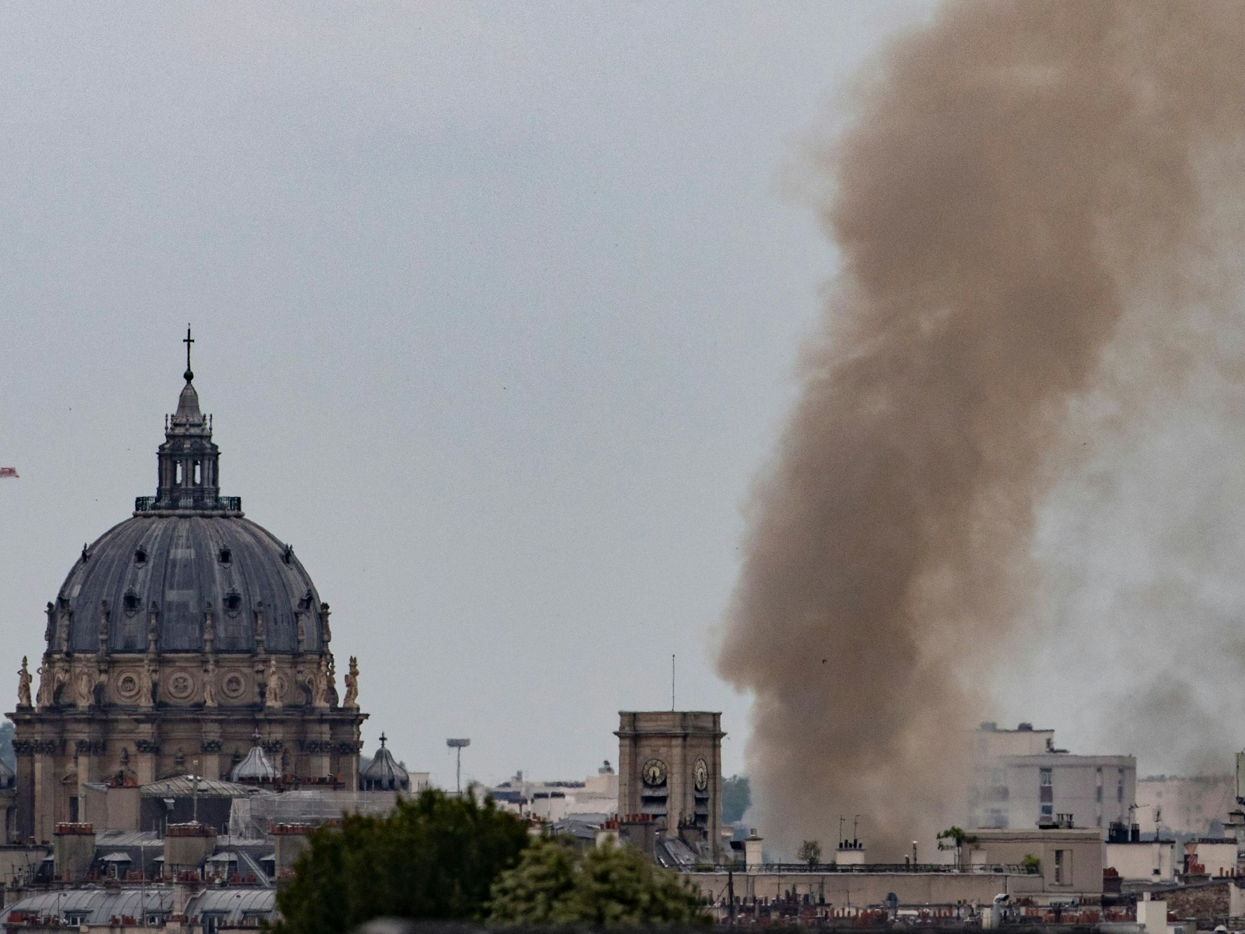 Diese Gesamtansicht zeigt Rauch, der aus einem Gebäude am Place Alphonse-Laveran in der Nähe des Doms des Val de Grace (L) im 5. Arrondissement von Paris aufsteigt.