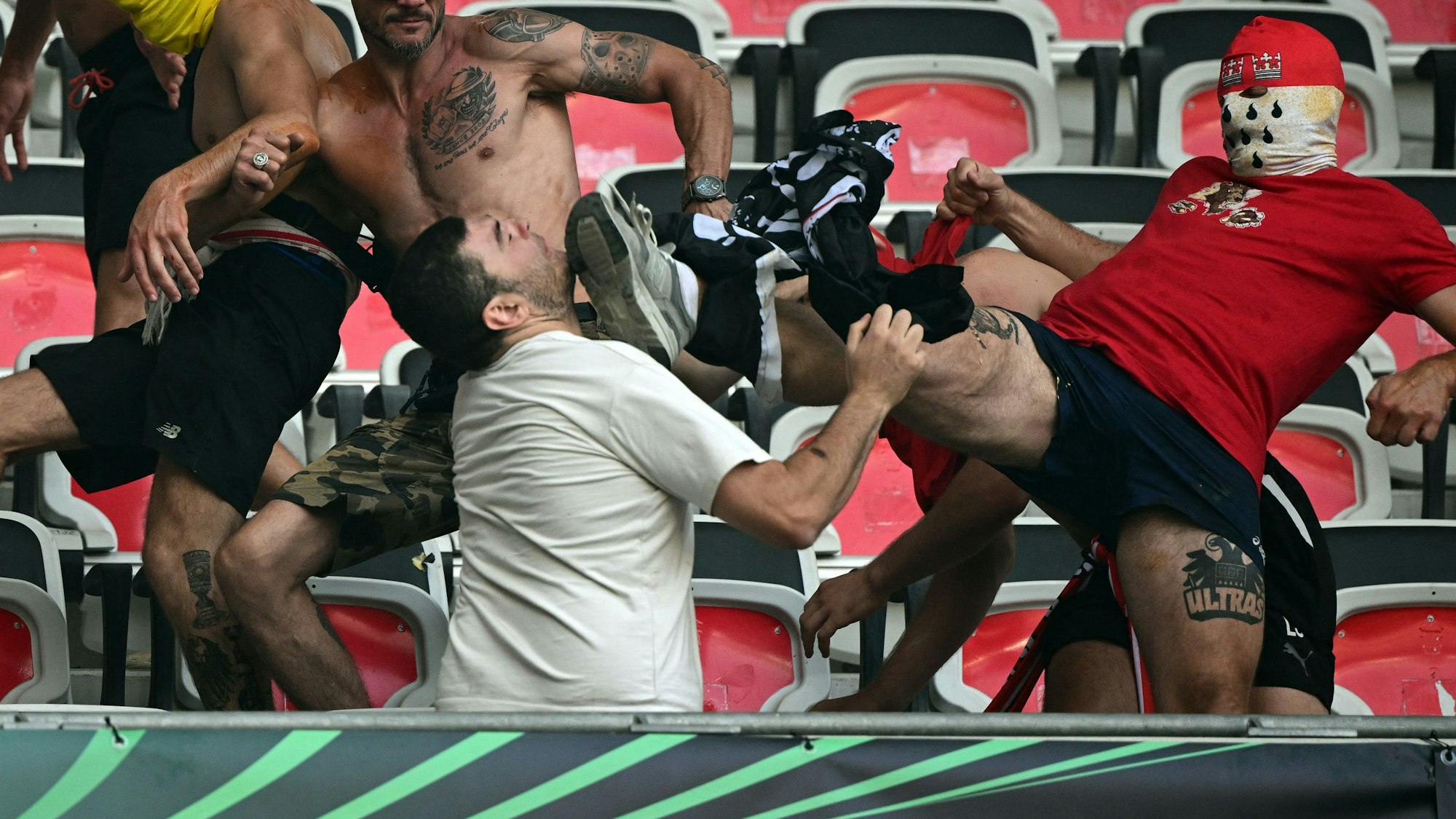 Der vermummte Ultra-Anhänger des 1. FC Köln bei seinem Tritt im Nizza-Stadion.