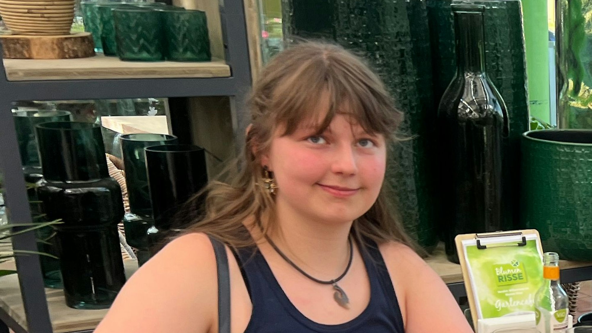 Das Porträtbild zeigt Abiturientin Amelie Stratmann. Sie hat braunes Haar, trägt eine Halskette und ein schwarzes Top.