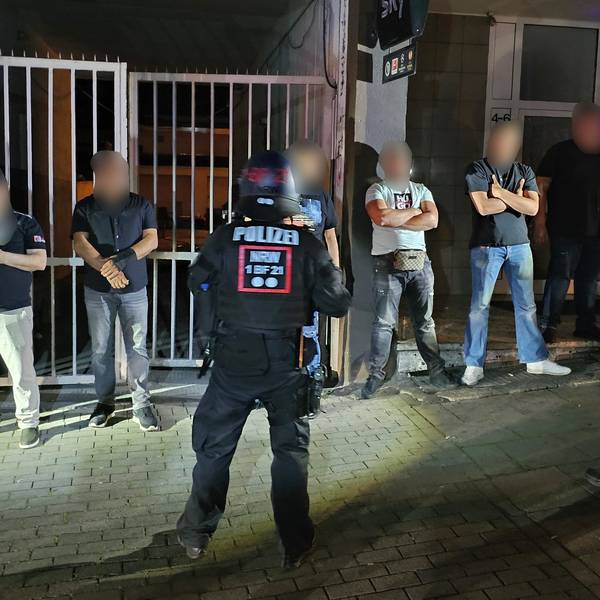 17.06.2023, Nordrhein-Westfalen, Essen: Polizisten bewachen Mitglieder einer der beteiligten Gruppen einer Schlägerei in der Innenstadt. In der Nacht zum Samstag ist es dort zu gewalttätigen Auseinandersetzungen zwischen mehreren Gruppen gekommen. Hunderte Menschen hatten sich aus bislang ungeklärter Ursache im Innenstadtbereich versammelt, wie eine Polizeisprecherin sagte. Foto: Markus Gayk/dpa +++ dpa-Bildfunk +++