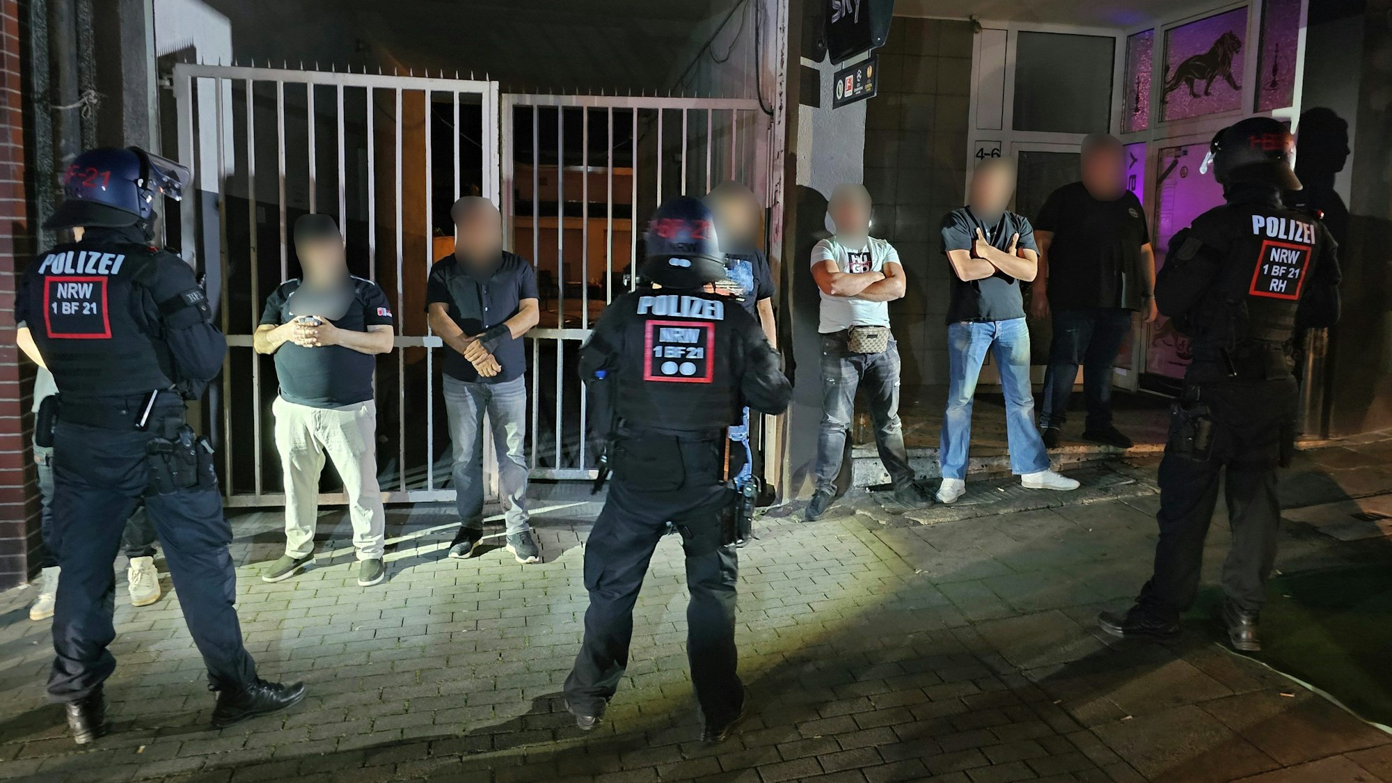 Essen: Polizisten bewachen Mitglieder einer der beteiligten Gruppen einer Schlägerei in der Innenstadt. In der Nacht zum Samstag war es dort zu gewalttätigen Auseinandersetzungen zwischen mehreren Gruppen gekommen.